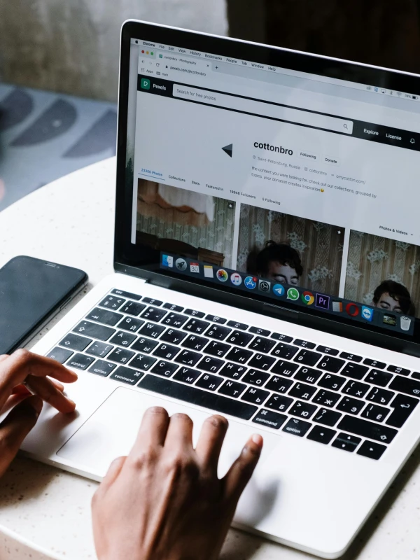 Persona usando una laptop con una página web de Pexels abierta mostrando un perfil de usuario