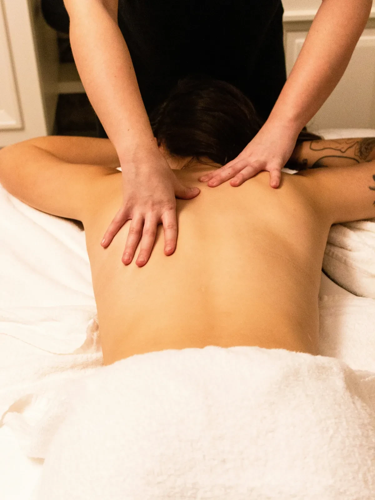 Una mujer recibiendo un masaje en la espalda por un terapeuta en un spa