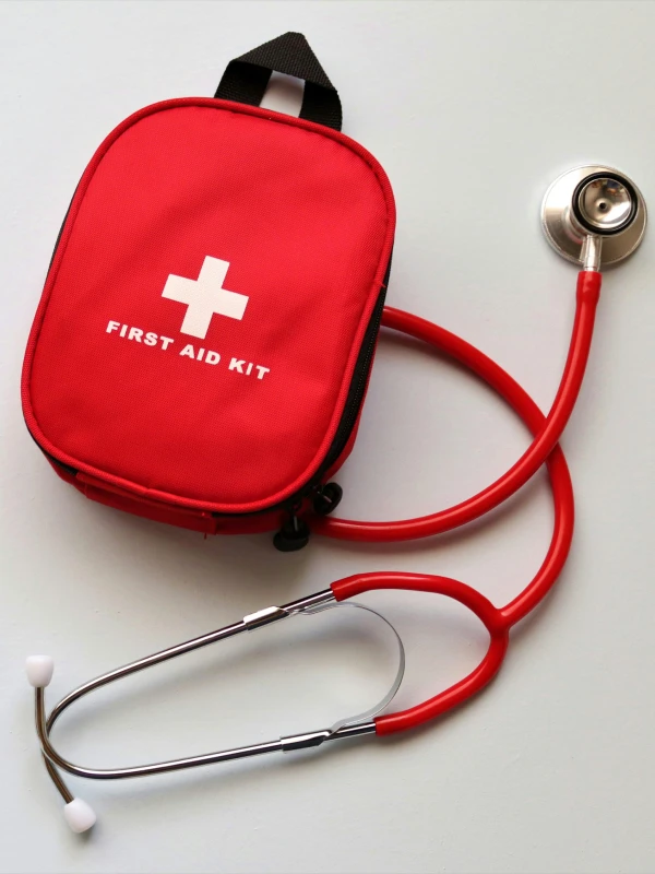Kit de primeros auxilios rojo con estetoscopio sobre fondo blanco