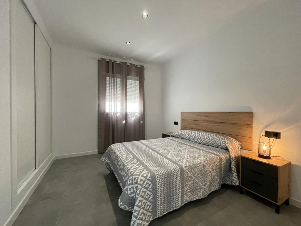 Habitación de hotel con cama doble y lámpara de noche